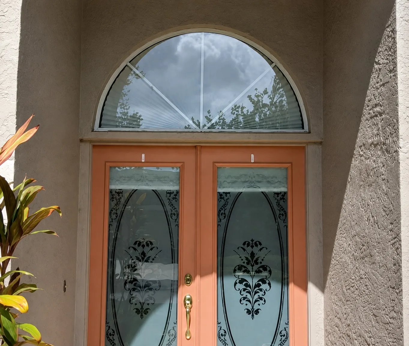 Arched front entry with double doors before the screen enclosure installation