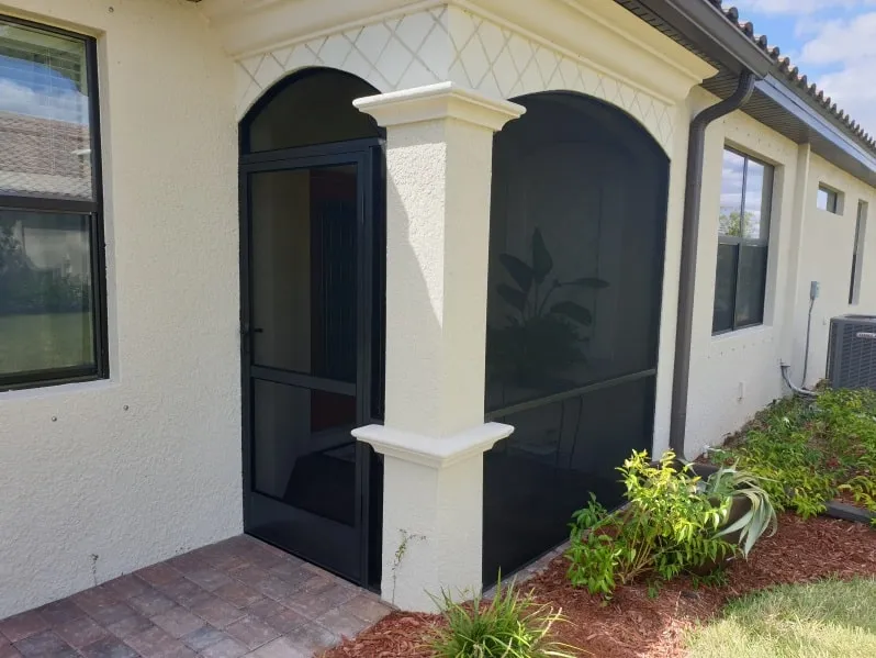 Front entry screen enclosure with arched opening on a Florida home