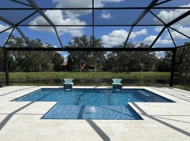 Geometric pool with a Baja shelf and spill bowls inside a screen enclosure in Sarasota