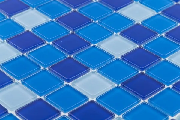Close-up of glass mosaic tiles in cobalt, sky blue, and white forming a checkerboard pool accent pattern