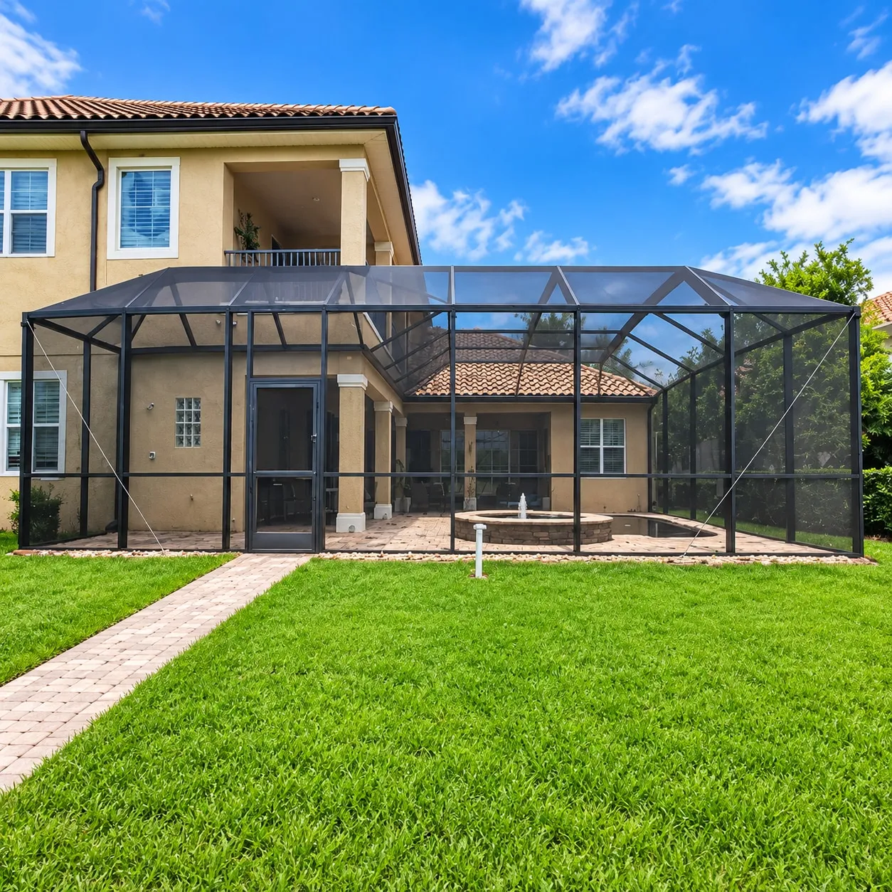 Aluminum screen enclosure with a mansard roof wrapping the lanai and pool of a two-storey Florida home