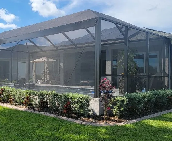 Modern screened porch enclosure surrounding a pool area, offering shade, bug protection, and open outdoor living in Florida.