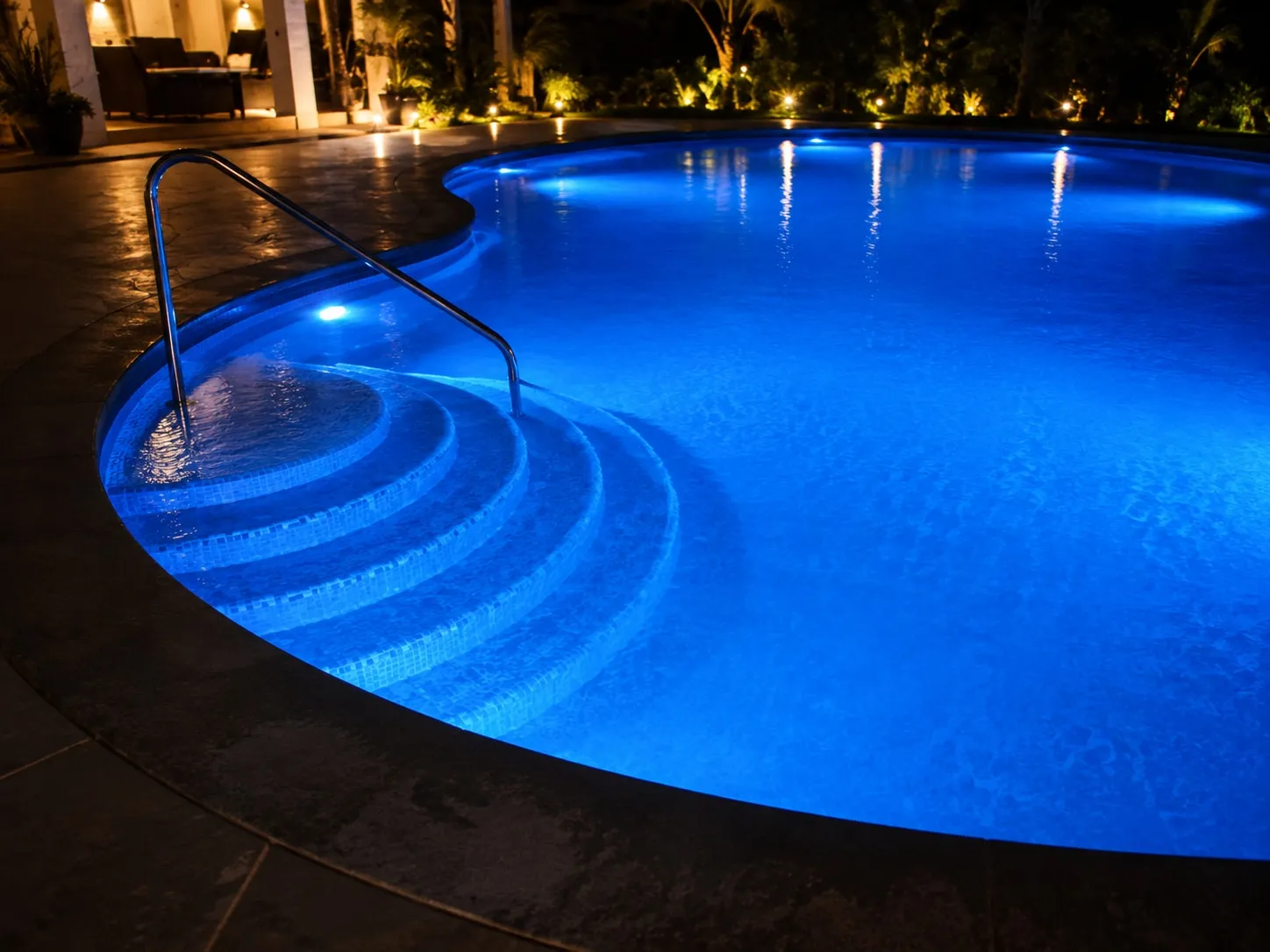 LED-lit swimming pool with curved steps at night