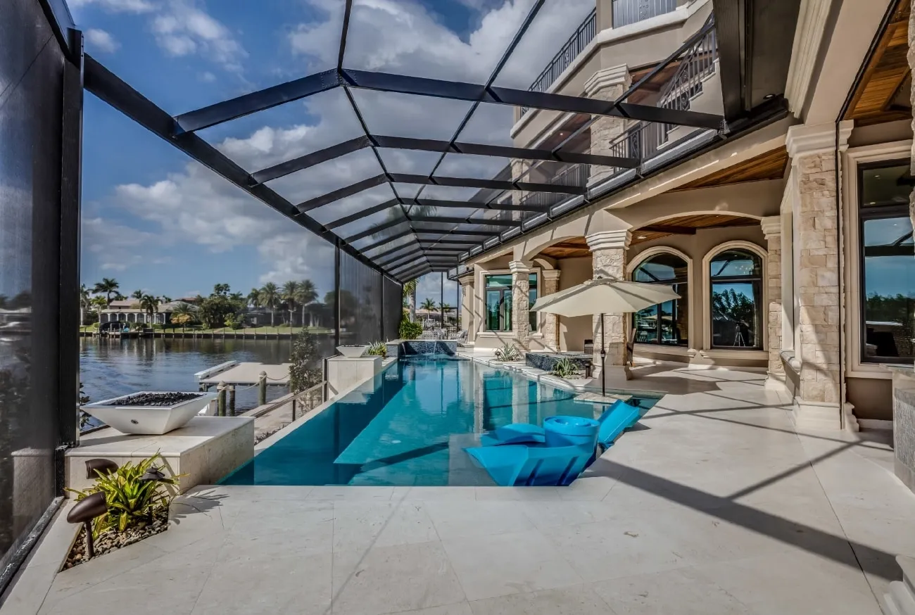 Clear View pool cage over a waterfront infinity pool at a Tampa home, wide panels framing the canal view