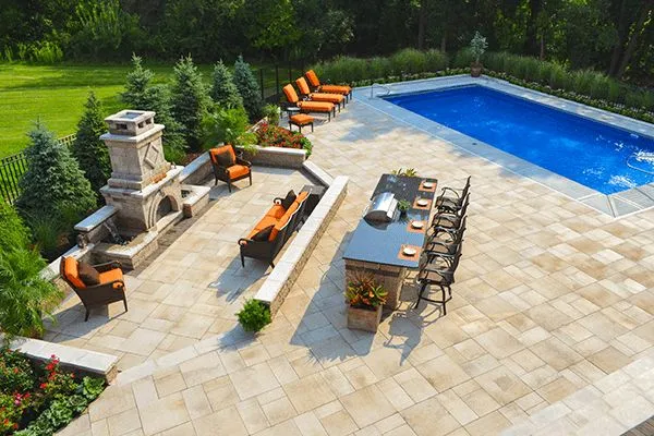 Outdoor patio with custom paver flooring, pool area, and built-in seating in Sarasota Florida