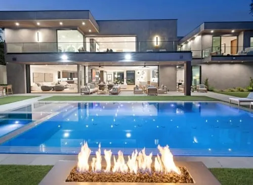 Modern custom swimming pool in Sarasota, FL with LED lighting, integrated spa and a fire feature at a luxury home.