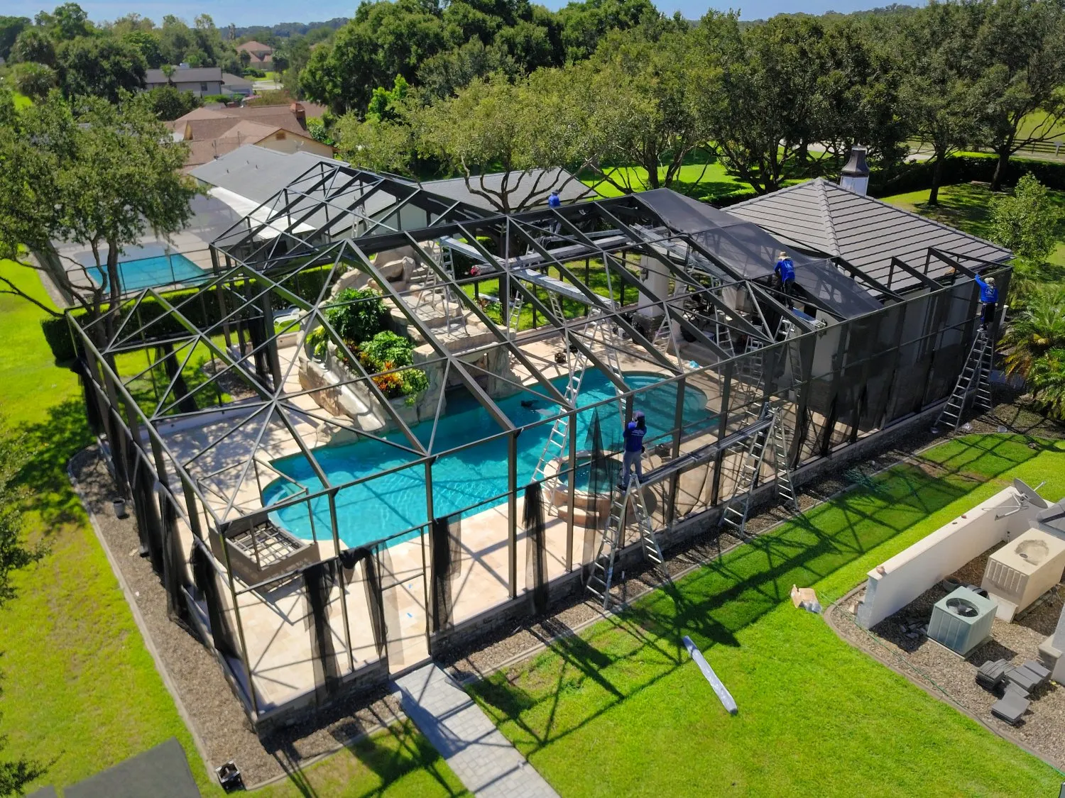 Aerial view of a screened pool enclosure being rescreened at a Florida home