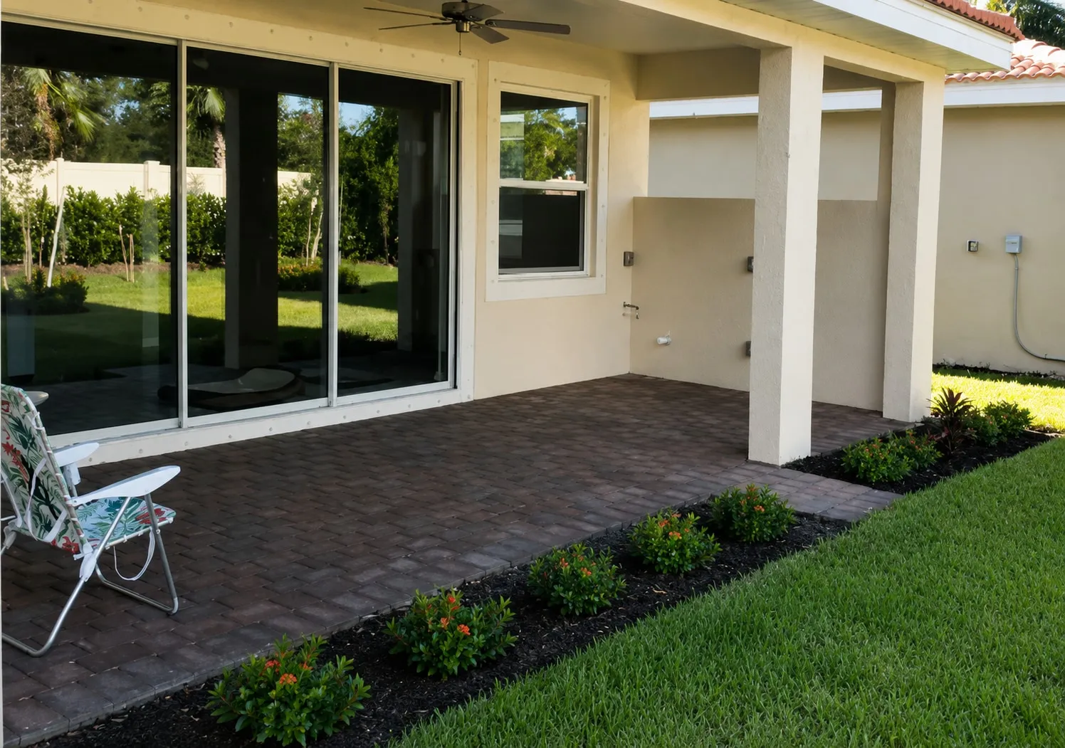 Open covered patio with paver floor and sliding glass doors before the screen enclosure installation