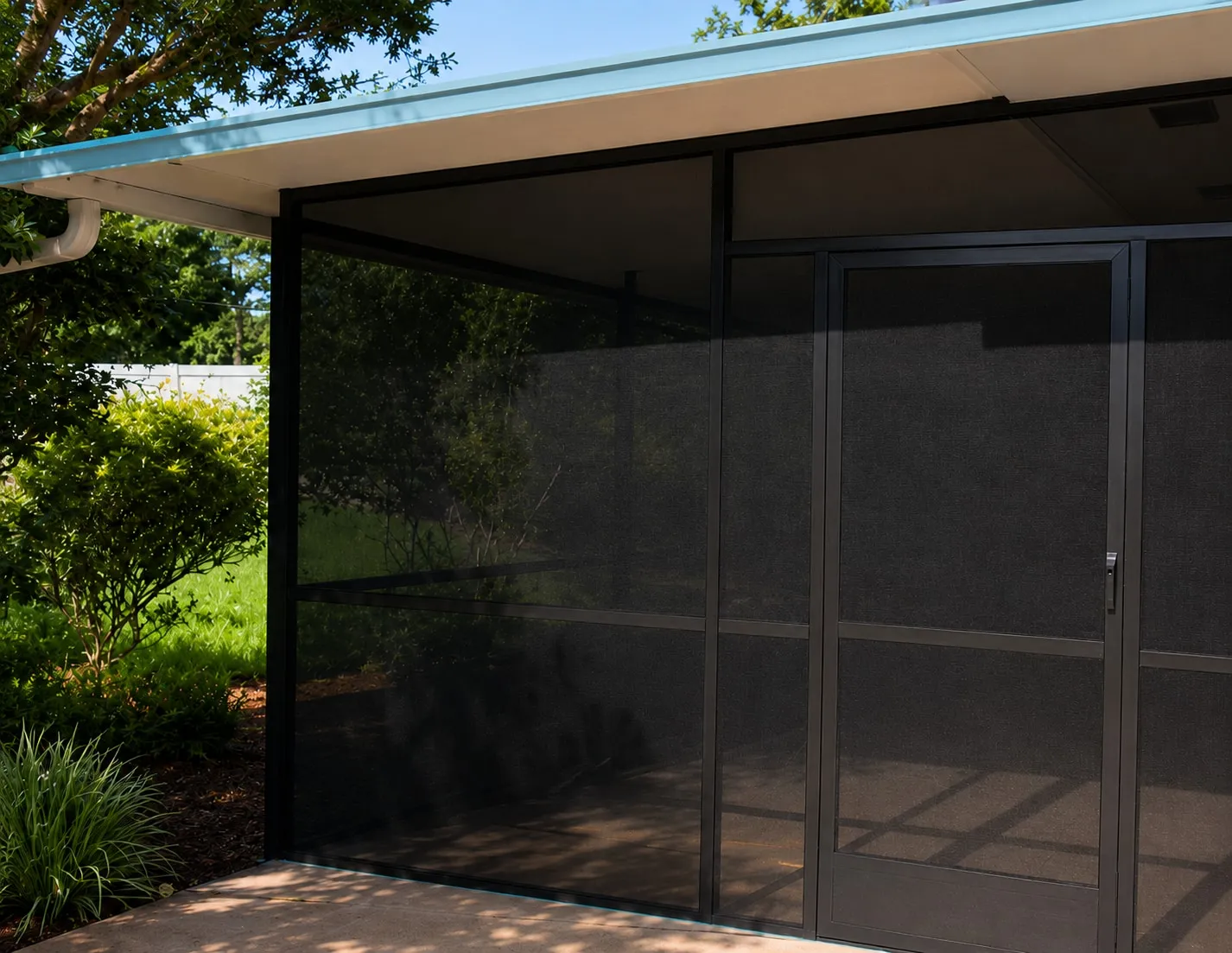 The same patio finished as a screened porch with dark mesh and a full-view screen door
