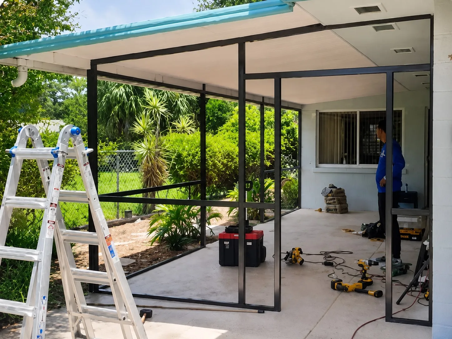 Aluminum frame going up over a covered patio during the screen enclosure installation