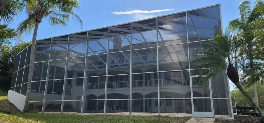 Two-story screen enclosure with fresh screens spanning the back of a Sarasota home