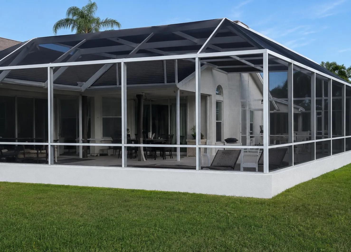 White pool screen enclosure with a solid kick plate running along the base of the mesh panels