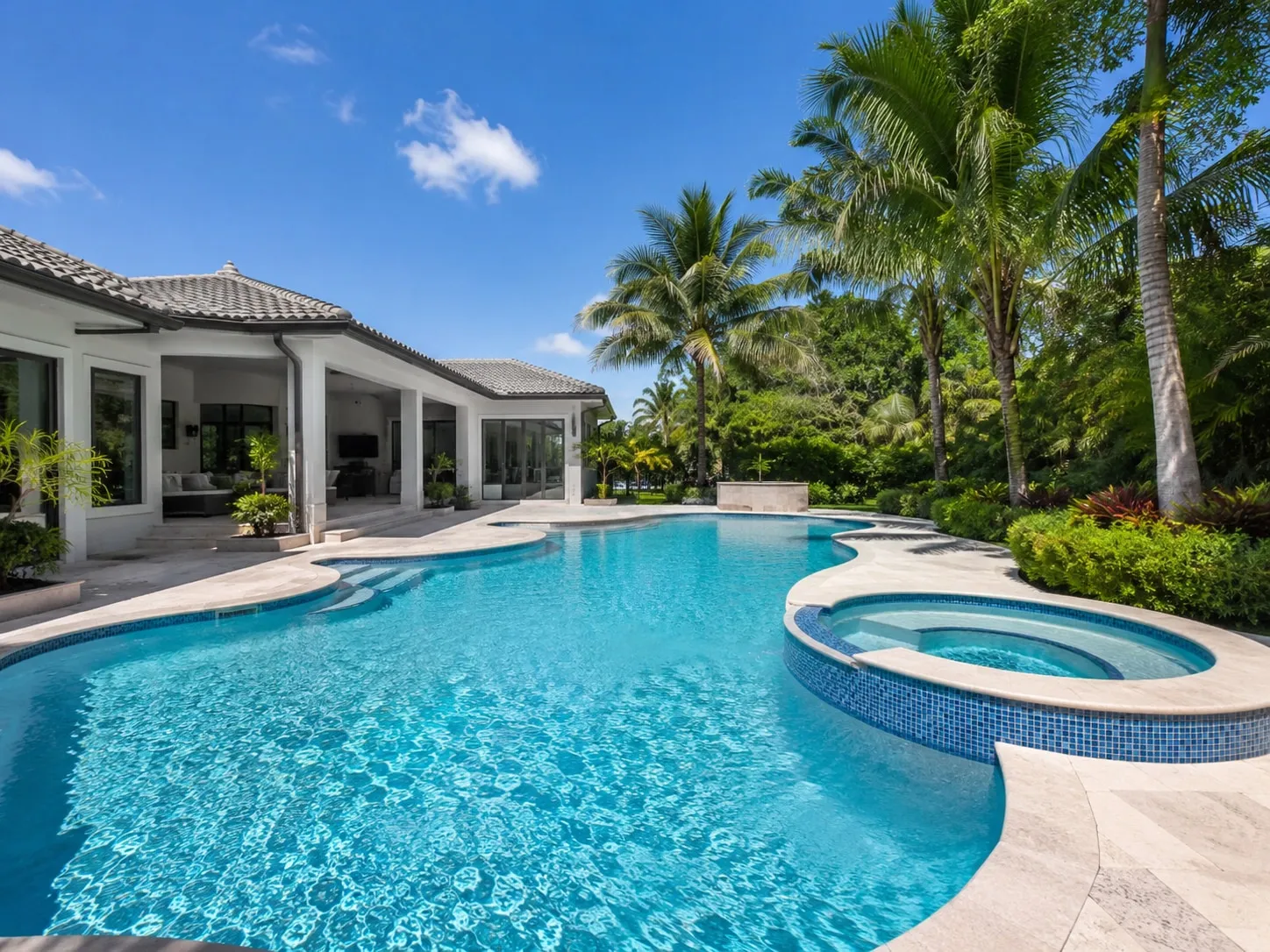 Freeform swimming pool with a raised spa and travertine deck at a Florida home